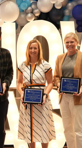 The five winners of the undergraduate research mentoring award, standing in front of a sign reading, "SHOWCASE"